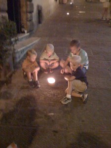 The boys huddle around the candles set for the evening parade